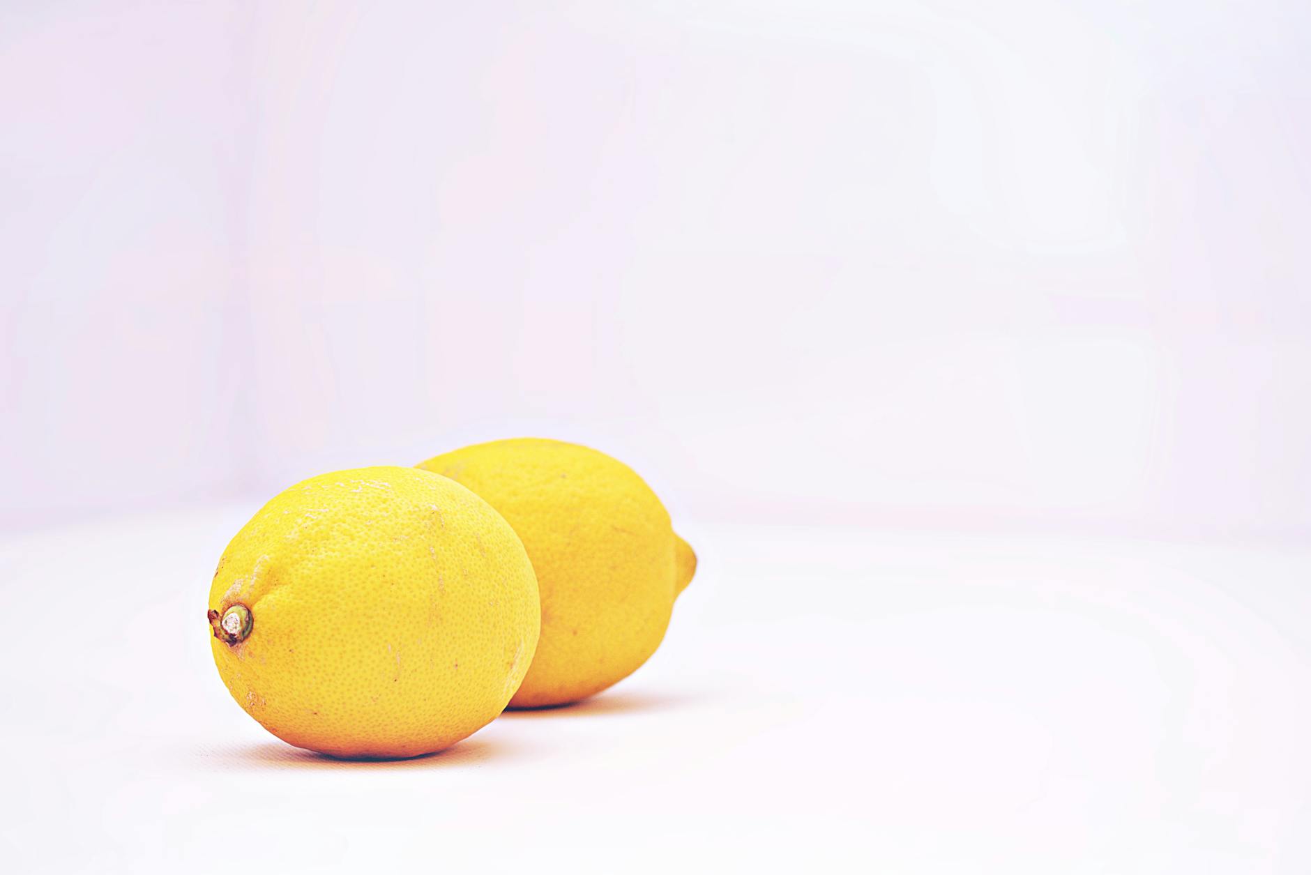 Two vibrant lemons against a white background, symbolizing freshness and sensation during midlife transitions