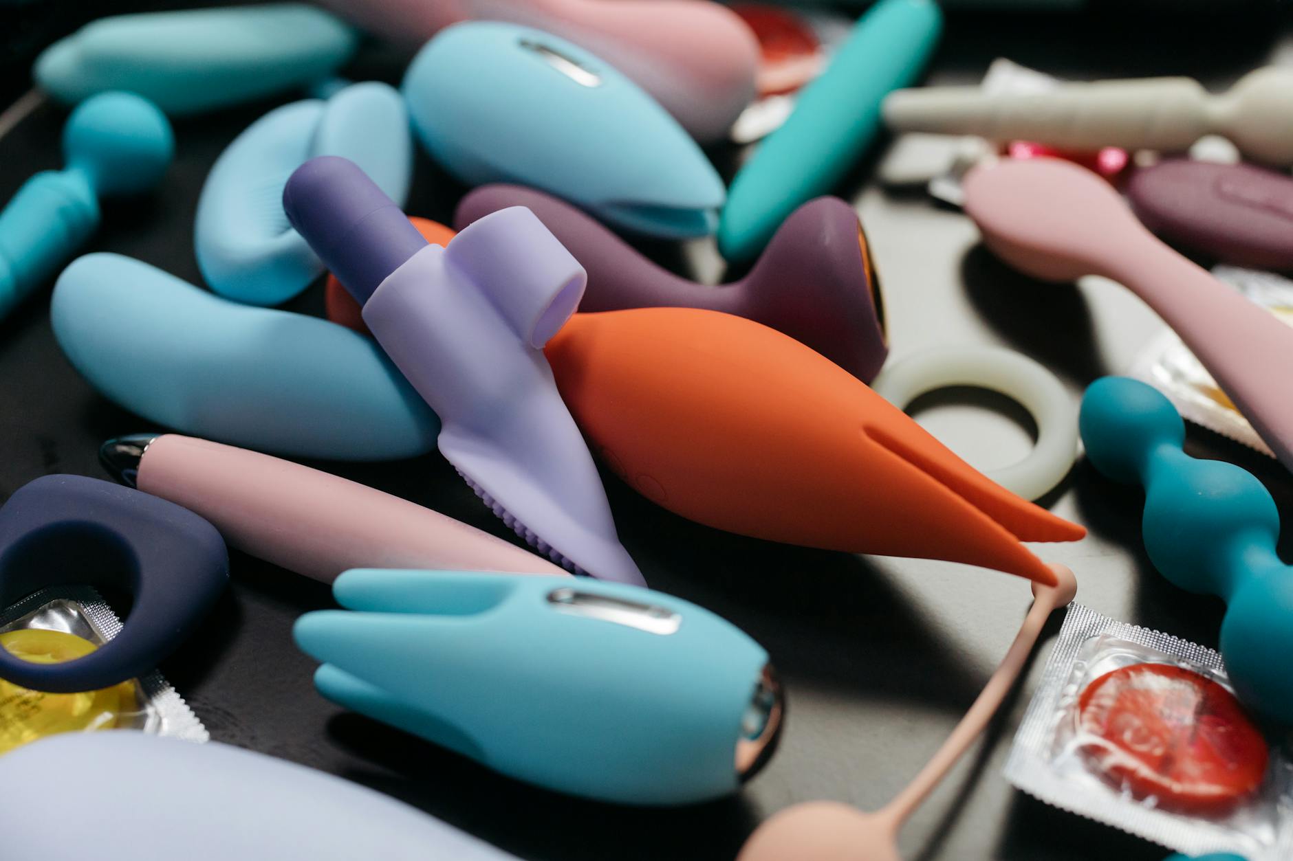 Woman holding a vibrator in a thoughtful pose, representing intentional pleasure exploration