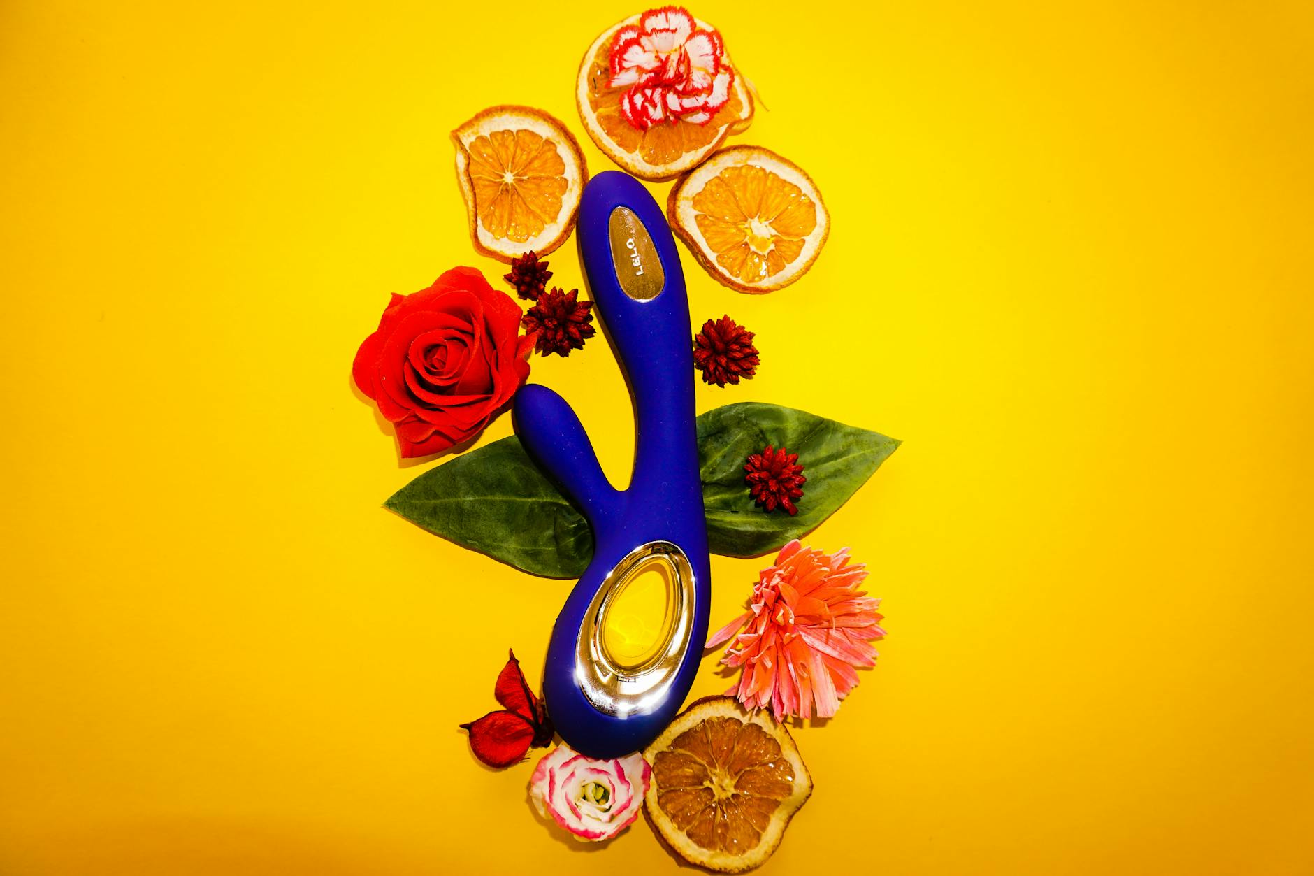 Yellow silicone vibrator surrounded by peeled bananas on a bright yellow background